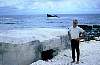 Ken Collins at Wake Island while on the way home with Article 131. In the background is a Japanese pillbox and a sunken ship